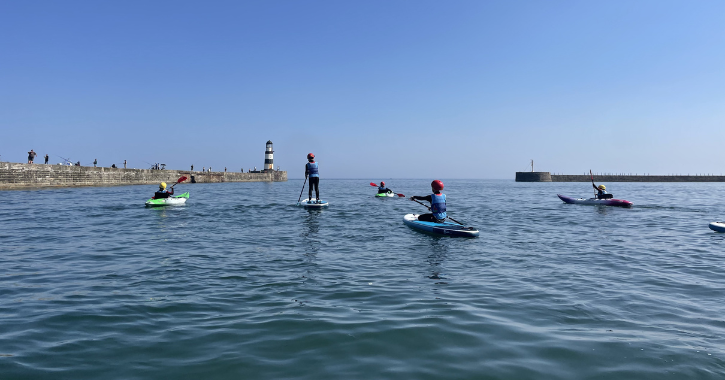 Group of children paddleboarding at Seaham Harbour Marina County Durham